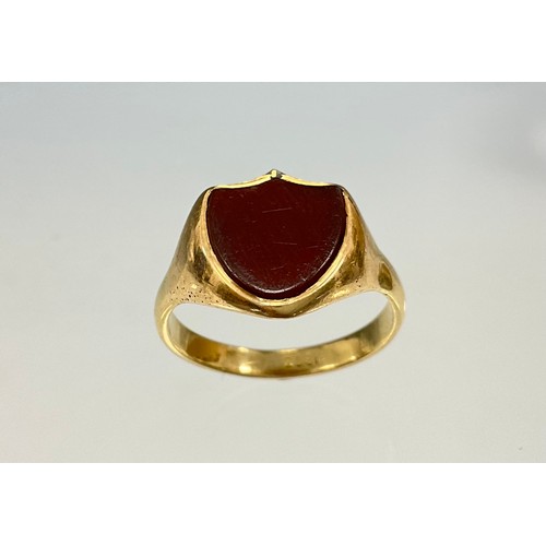 6243 - An 18ct gold shield design carnelian signet ring, set with a shield shaped cabochon carnelian, stamp... 