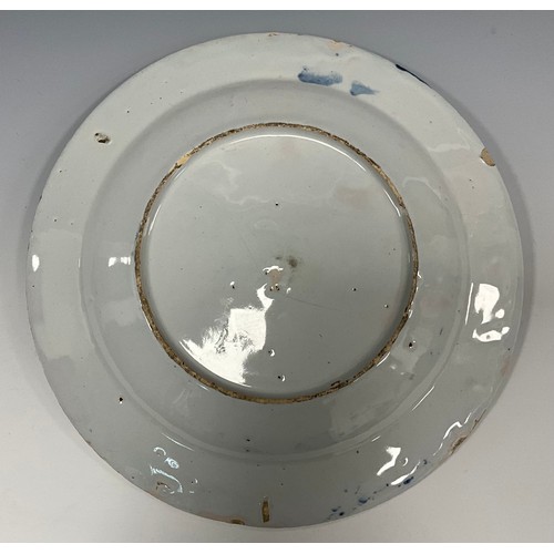 6291 - A 18th century English Delftware shallow dish, painted elder and garden on under glazed blue ground,... 