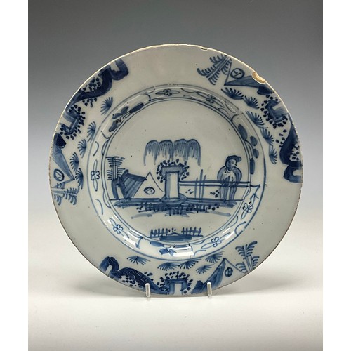6291 - A 18th century English Delftware shallow dish, painted elder and garden on under glazed blue ground,... 