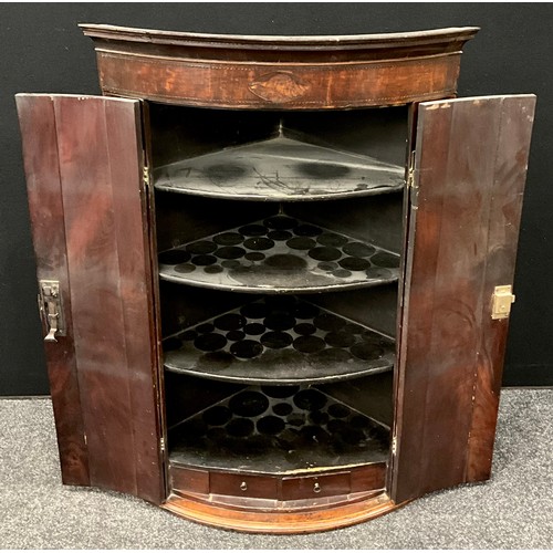 3 - A George III mahogany bow-front corner cupboard, inlaid shell patera to frieze, above a pair of door... 