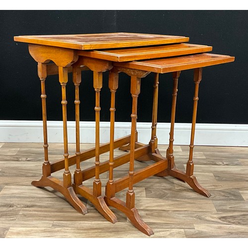 A graduated nest of three Regency style yew wood occasional tables ...