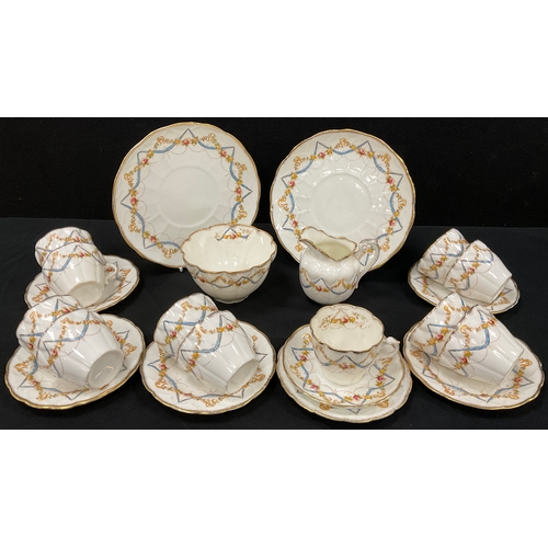 69 - An early 20th century tea set, decorated with roses and ribbon swags comprised of, two picnic plates... 