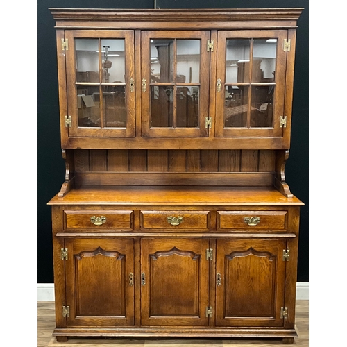 85 - A late 20th century oak dresser in the manner of Titchmarsh and Goodwin, moulded cornice above three... 