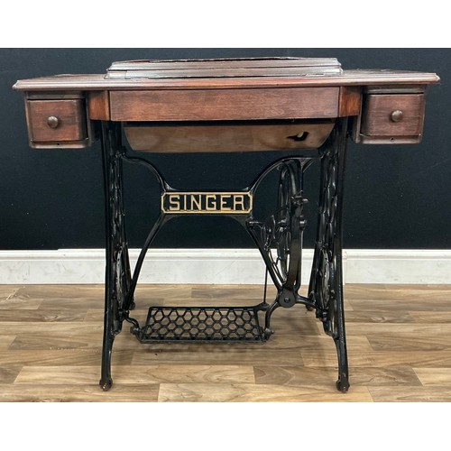195 - A treadle Singer sewing machine, with an oak and cast iron table base, 77cm high.