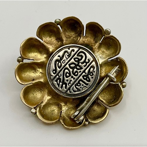 323 - A middle eastern tested between 14ct-18ct gold garnet set brooch, 
with inset approx. 3.7mm round ol... 