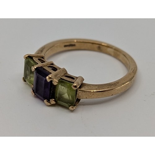 349 - A 9ct gold peridot and amethyst set trilogy ring,
set with a central approx. 0.40ct rectangular step... 