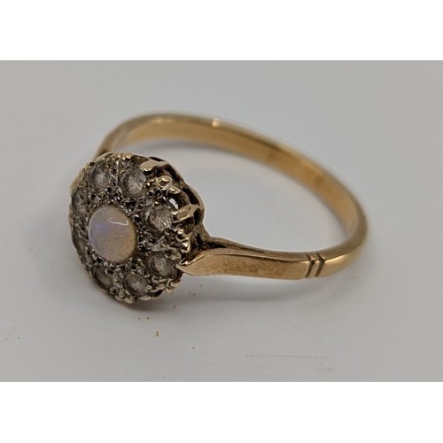 355 - A 9ct gold opal and cubic zirconia cluster ring,
set with an approx. 4mm round cabochon opal, displa... 