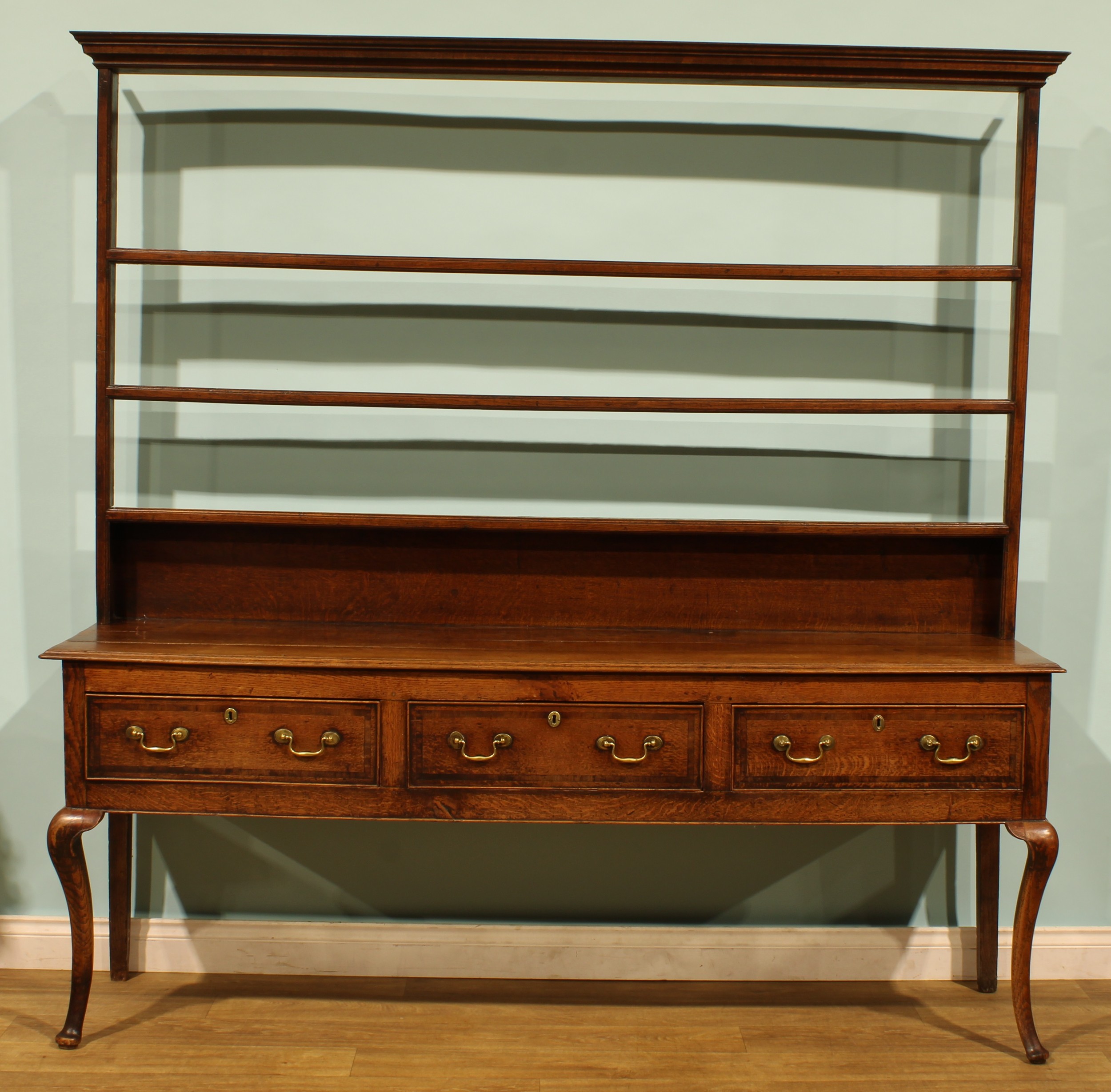 A George III oak dresser, moulded cornice above three plate rack ...