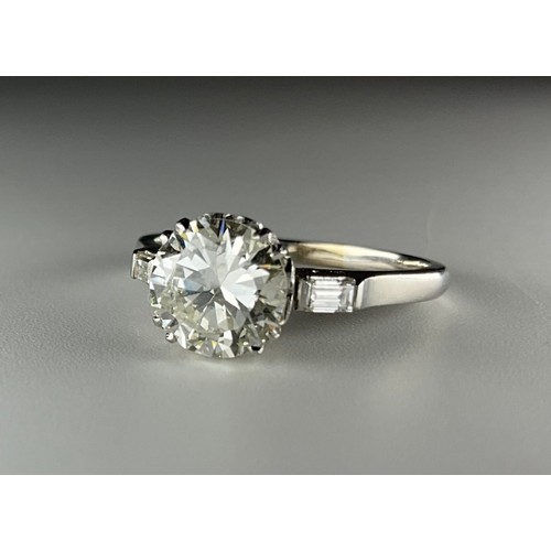 140 - A platinum solitaire diamond ring, with diamond set shoulders, set with an approx. 1.65ct round bril... 