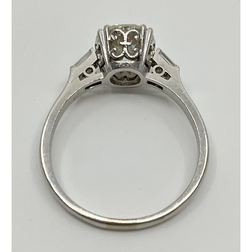 140 - A platinum solitaire diamond ring, with diamond set shoulders, set with an approx. 1.65ct round bril... 