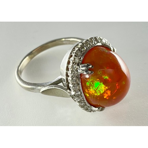 145 - A cabochon fire opal and diamond ring - the tested 18ct white gold ring, set with an approx. 7.10ct ... 