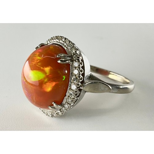 145 - A cabochon fire opal and diamond ring - the tested 18ct white gold ring, set with an approx. 7.10ct ... 