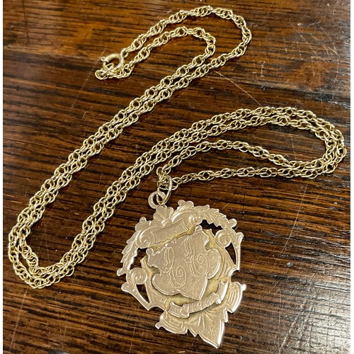 348 - A 9ct rose gold medallion pendant with tested 9ct gold chain, 
the pendant engraved with initials on... 