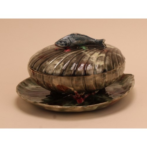 147 - A 19th century Majolica covered sardine dish and stand, scallop shell form with fish handle, coral f... 