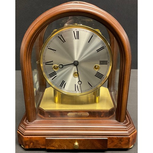 173 - A Franz Hermle part skeleton mantel clock, the arch topped glass case enclosing a silvered circular ... 