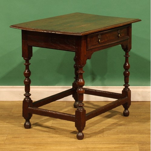 10 - An 18th century oak side table, rectangular top above a long frieze drawer, turned and blocked legs,... 