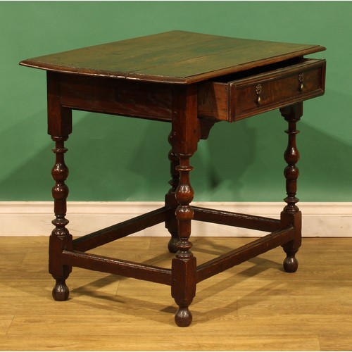 10 - An 18th century oak side table, rectangular top above a long frieze drawer, turned and blocked legs,... 