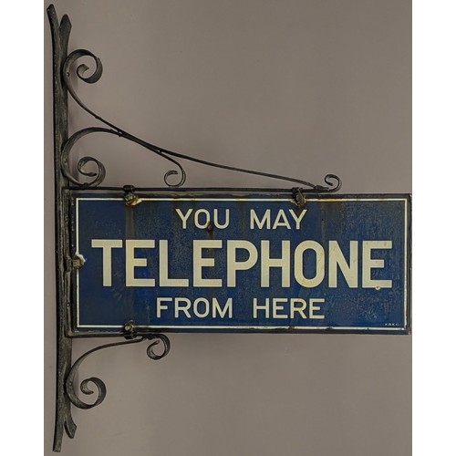 3042 - A mid 20th century rectangular double sided enamel sign, You May Telephone From Here, inscribed in w... 