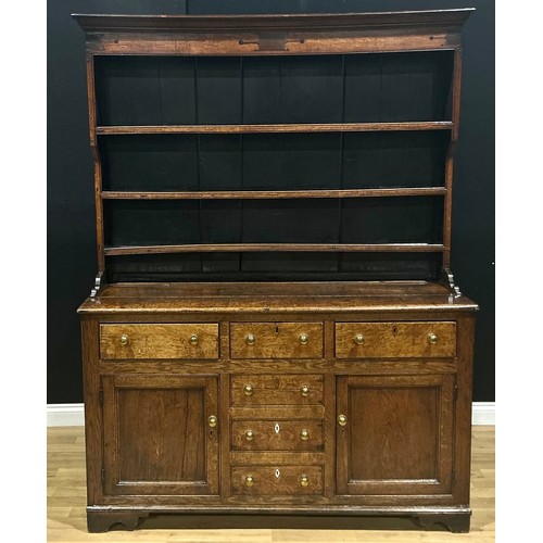 1 - A George III oak dresser, moulded cornice above three plate rack shelves, the projecting base with a... 