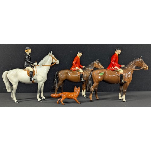5024 - A Beswick hunting group comprising lady on dappled grey horse, pair of huntsmen in red livery on bay... 