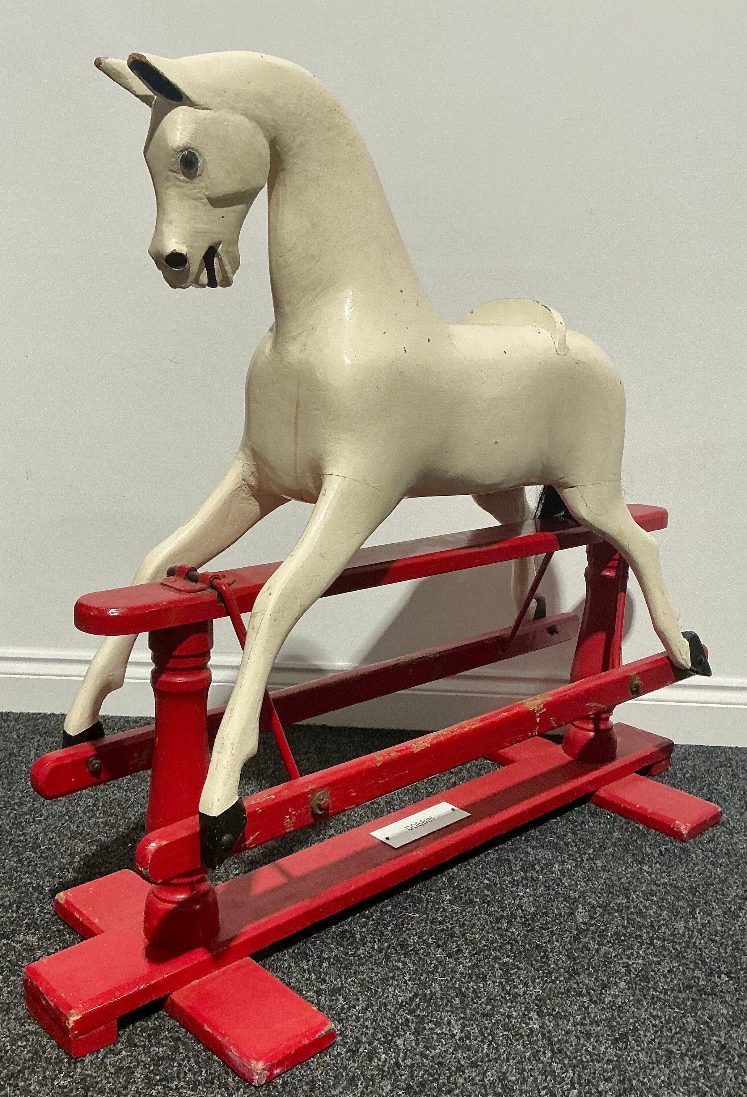 An early 20th century rocking horse, painted white, mounted on a red ...