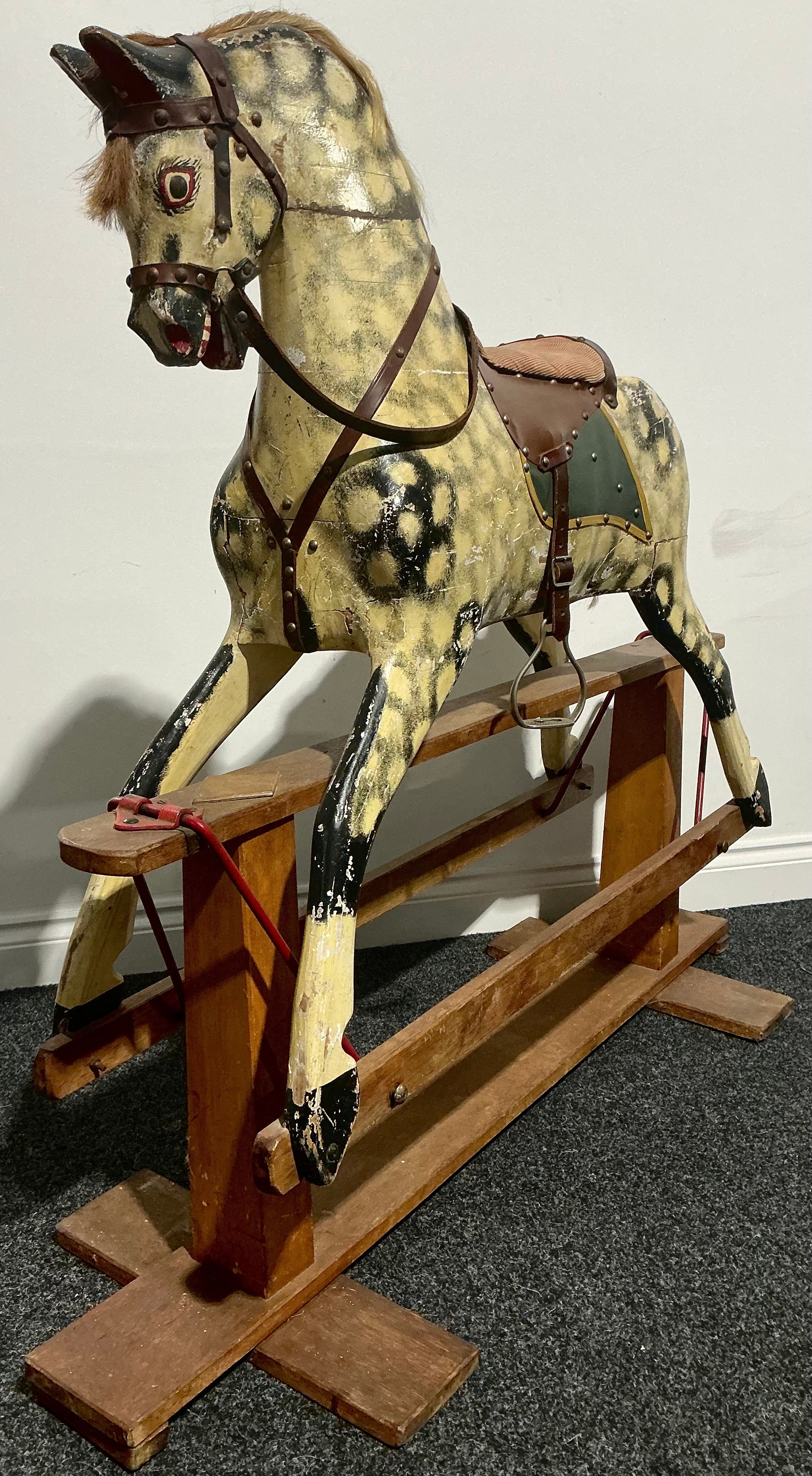 An Edwardian rocking horse, the carved and painted dapple grey body ...