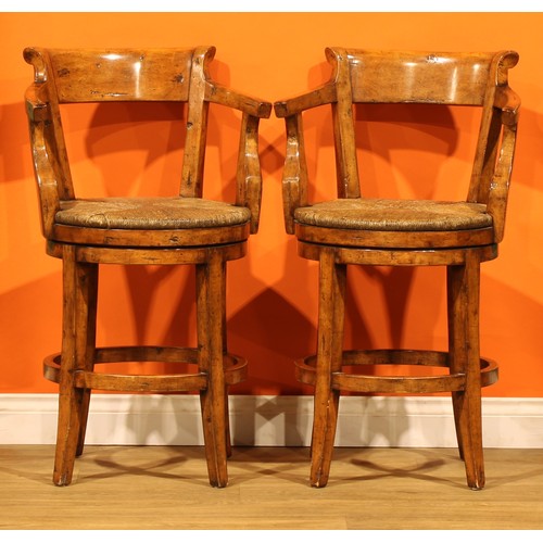 A pair of contemporary fruitwood swivel bar stools, possibly Guy ...