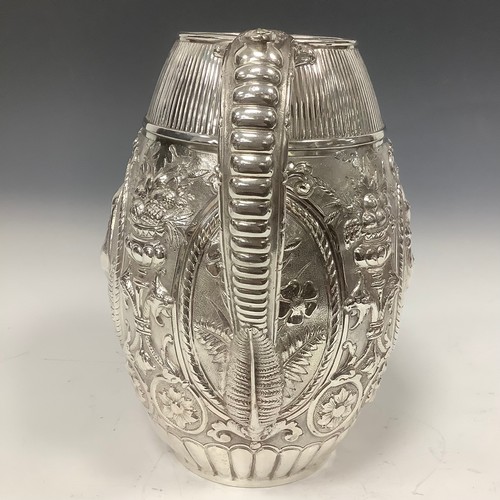 22 - A late Victorian E.P.N.S barrel shaped beer jug, chased with cranes, baskets of fruit, flowers and s... 