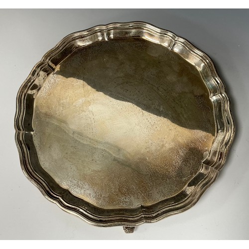 140 - A George V silver salver, circular form with pie crust rim, three scrolled feet, Garrard & Co Ltd, L... 