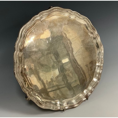 140 - A George V silver salver, circular form with pie crust rim, three scrolled feet, Garrard & Co Ltd, L... 