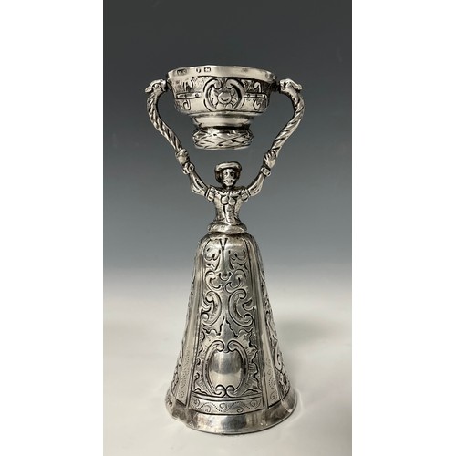 166 - A 19th century Dutch silver bell shaped wager cup, as a mustachioed gent in full skirts, chased and ... 