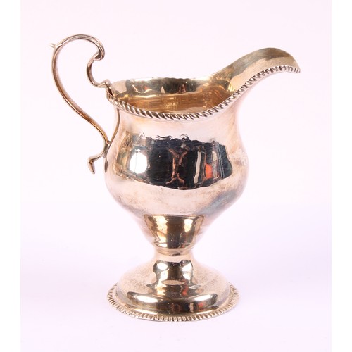 57 - A George II silver ogee shaped pedestal cream jug, gadrooned borders, acanthus capped scroll handle,... 
