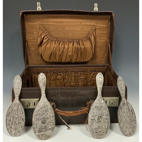 124 - A pair of late 19th century Anglo-Indian silver hairbrushes, repousse worked with huts, villagers, c... 