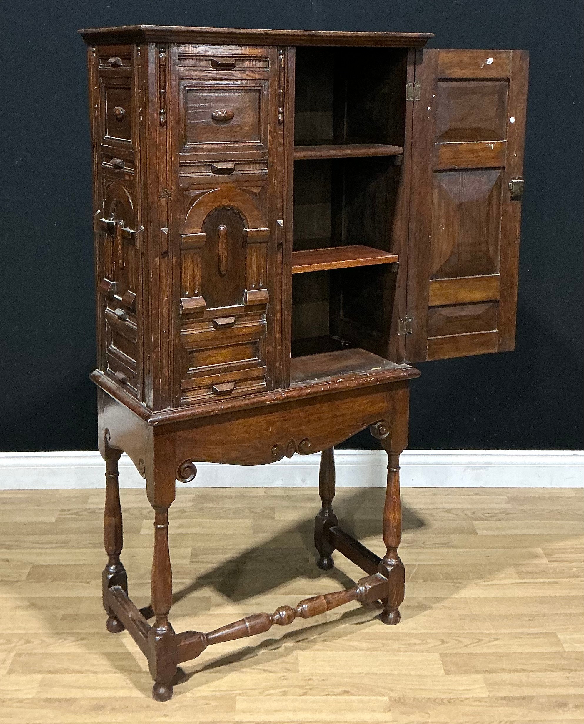 A Charles II style oak pier cupboard, the pair of panel doors above a ...