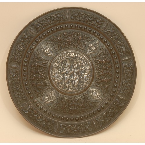 3919 - A 19th century Indian silver overlaid copper circular charger, chased with deities and lotus, 31cm d... 
