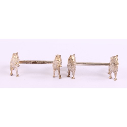 44 - A pair of silver plated novelty knife rests, each cast with a pair of dogs, 9cm wide, 20th century