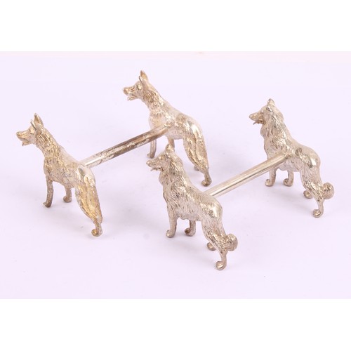 44 - A pair of silver plated novelty knife rests, each cast with a pair of dogs, 9cm wide, 20th century