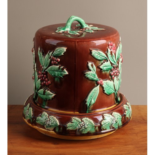 768 - A 19th century majolica cheese dome and stand, moulded in relief with holly, 28cm high, c.1880