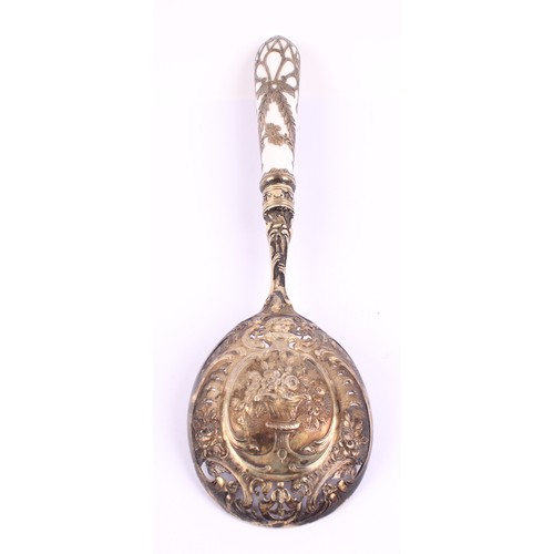 27 - A German silver gilt and porcelain mounted spoon, pierced and cast with flowering urns, busts and sc... 