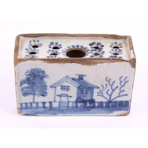 787 - An 18th century English Delft flower brick, probably Liverpool, decorated with a house, fence and tr... 
