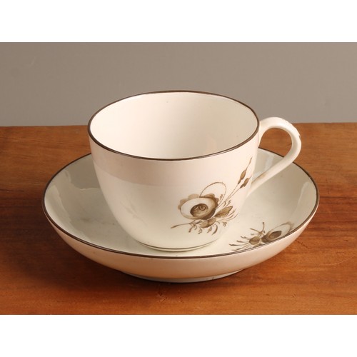 A Pinxton bute shaped teacup and saucer, painted in sepia with roses ...