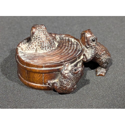A Japanese boxwood netsuke, bathing toads, glass eyes, signed mother of ...