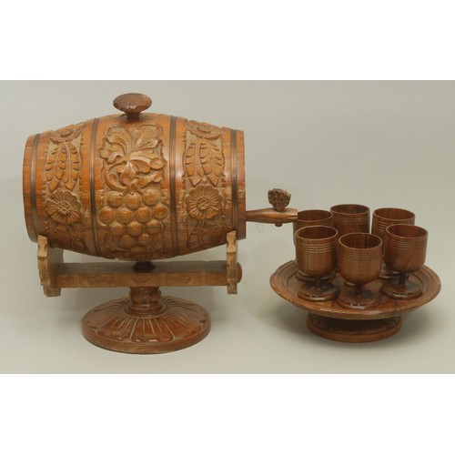 5589 - A Bulgarian carved treen handcrafted wine barrel, with accompanying set of six turned treen wine gla... 