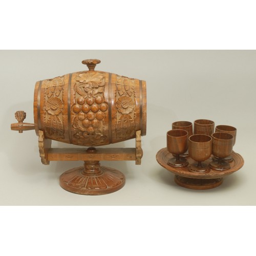 5589 - A Bulgarian carved treen handcrafted wine barrel, with accompanying set of six turned treen wine gla... 