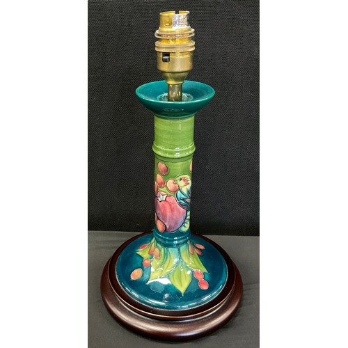 13 - A Moorcroft pottery table lamp, tube lined decoration of finch amongst fruit, mounted on circular wo... 