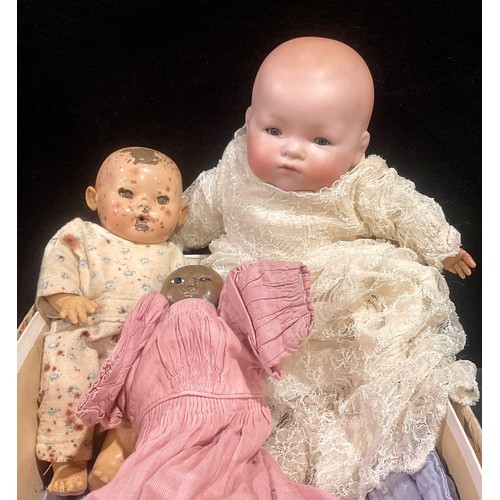 6040 - Dolls - A mixed group of three dolls, to include a carved wooden doll with painted features; Another... 