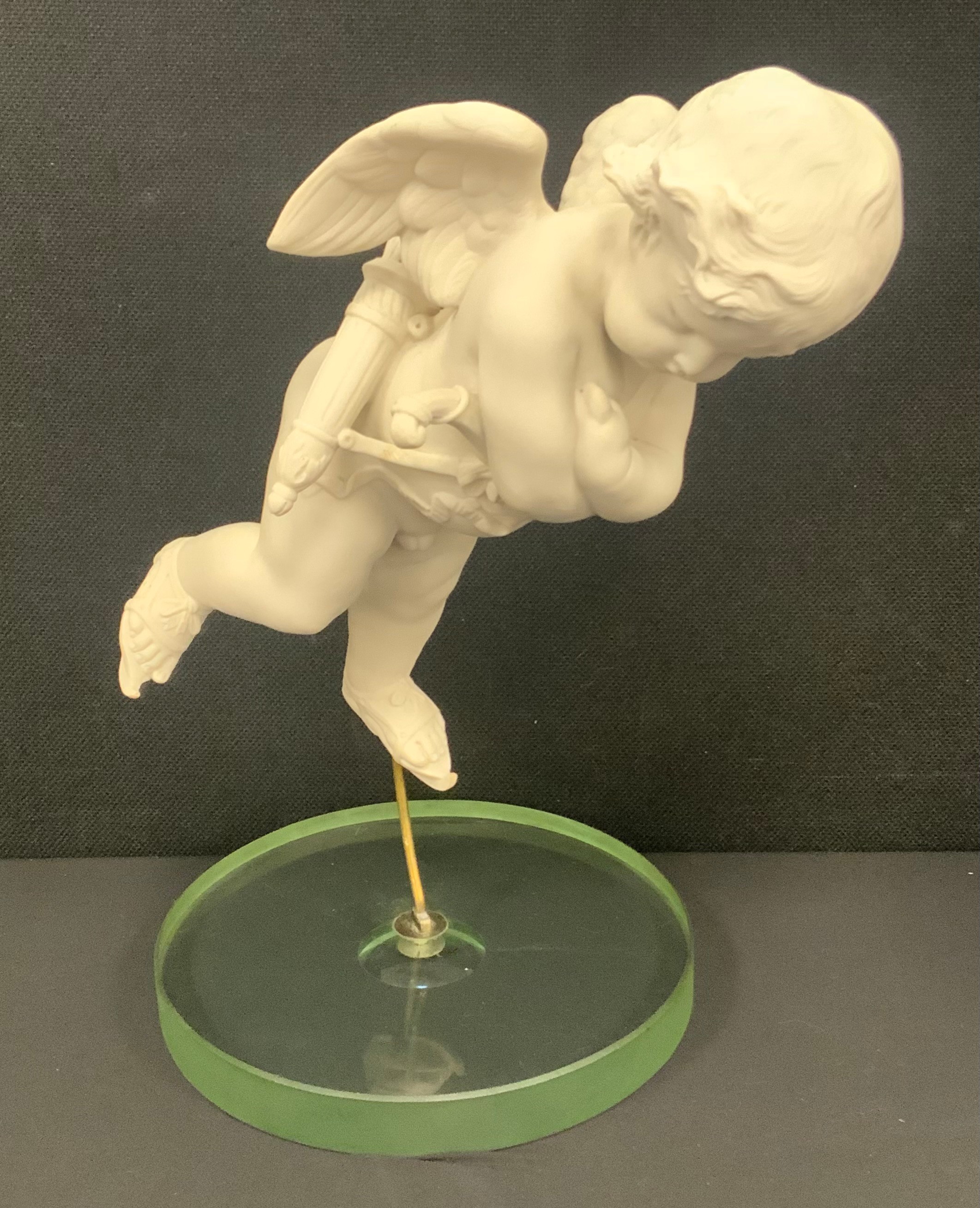 A Parian figure of Cupid, suspended in a horizontal position, mounted ...