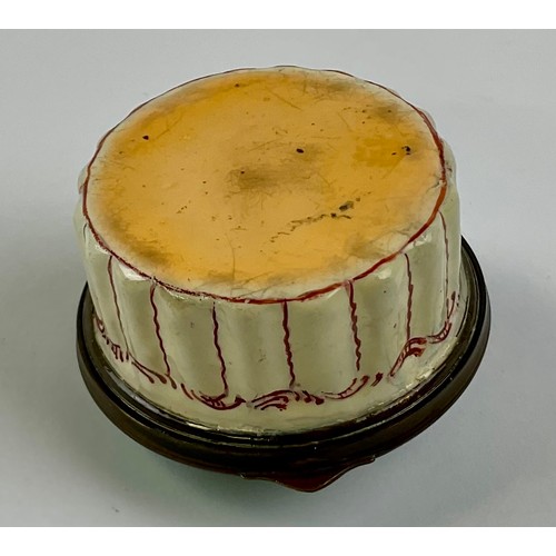 3054 - A George III Staffordshire enamel patch box, as a dog basket, the hinged cover cast with a spaniel, ... 