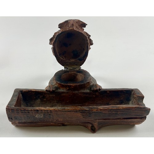 3000 - A Black Forest novelty inkwell, carved as a dog peering over a log, hinged cover, glass eyes, 12.5cm... 