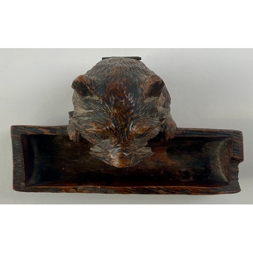 3000 - A Black Forest novelty inkwell, carved as a dog peering over a log, hinged cover, glass eyes, 12.5cm... 